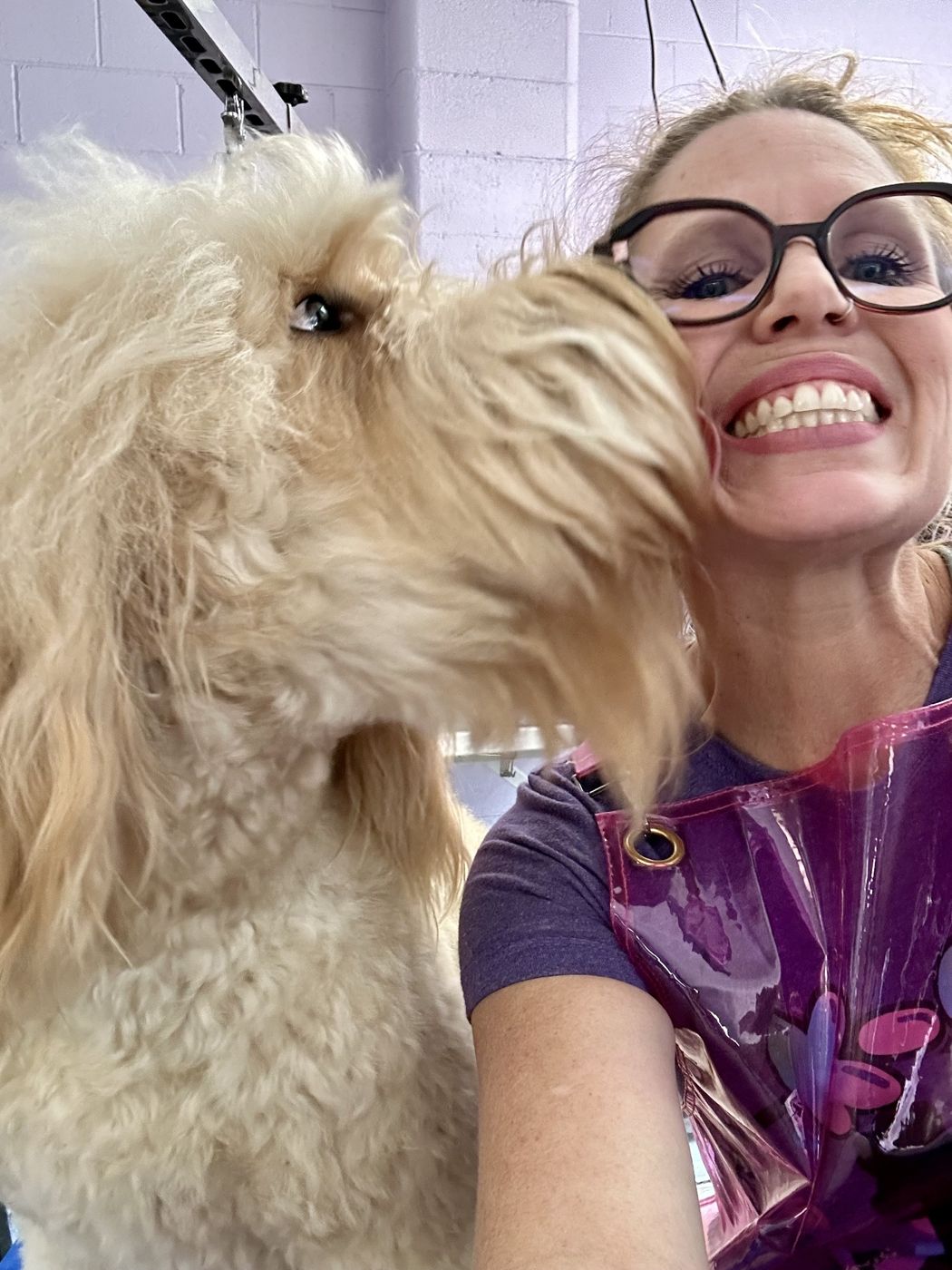 Heather getting a kiss from a golden doodle